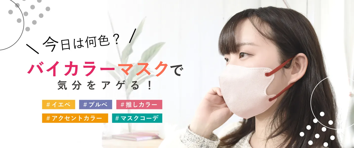 ピンクベージュの本体にレッドの耳ひもを合わせたバイカラーマスクを着けた女性